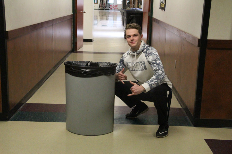 Ian Collins casually poses next to a garbage can.