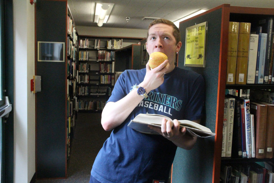 Jacob Huffer displays his intelligence, while reading a book, and eating an apple.